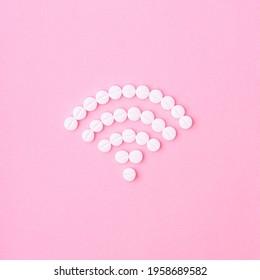 Sign For Wi Fi Internet Connection Made Of White Tablets On A Pink Background. Internet Communication Creative Concept. Flat Lay Minimal Composition.