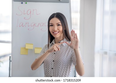 Sign. Young Sign Language Interpreter Pointing To Her Thumb