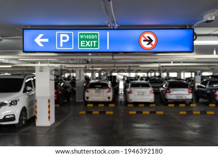 Signage Lightingbox in the indoor carparking, tell driver which way is parking lot or exit. Thai Language in green square on lightinbox means EXIT.