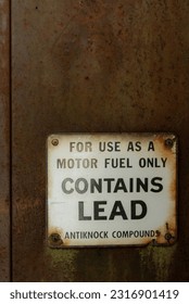 Signage on an antique, rusty gas pump. Contains lead.