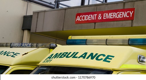 The Signage On Two NHS Ambulances Parked Underneath An Accident And Emergency Sign At A Hospital In The UK