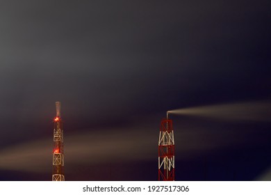 Signaled With Red Lights Smoke Pipes Of Petrochemical Plant At Night Dark Dramatic Sky Long Time Exposure Shot With Copyspace. Concept Of Environment Pollution Greenhouse Effect Global Warming