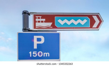 A signange on the street in Ireland showing the way to the ferry port and the bus station