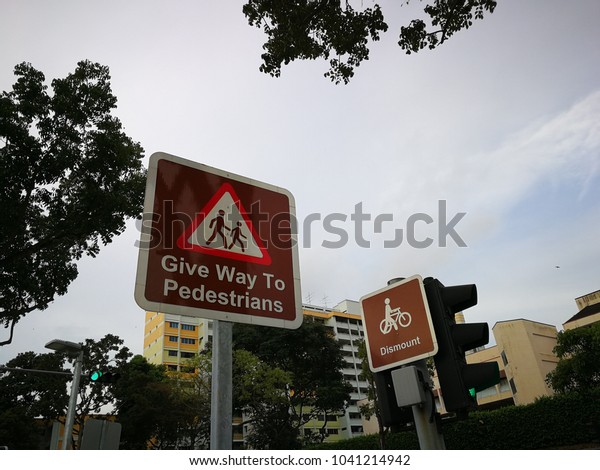 signboard\
give away to pedestrian taken during\
evening.