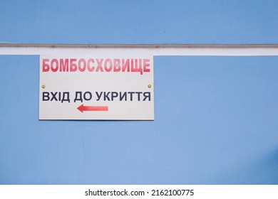Signboard with inscription in Ukrainian - Bombproof Shelter. Refuge entrance. Air raid warning. Emergency sign. Russia-Ukraine War 2022.