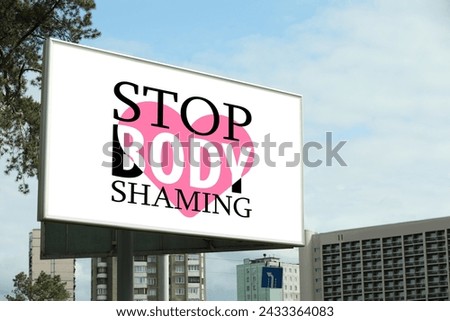 Signboard with phrase Stop Body Shaming and pink heart on city street