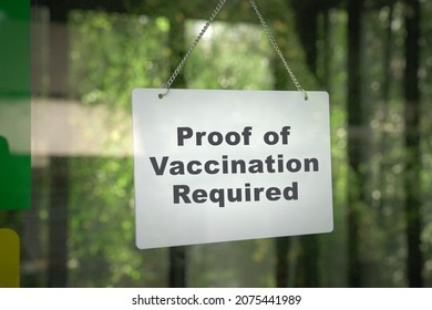 Signboard, Proof of Vaccination Required hanging on the door front of a shop. No vaccine, no entry concept. - Shutterstock ID 2075441989