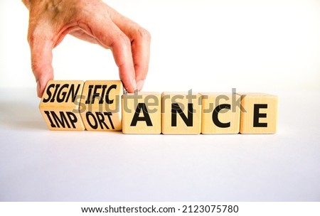Significance and importance symbol. Businessman turns cubes changes the word importance to significance. Beautiful white background, copy space. Business, significance and importance concept.