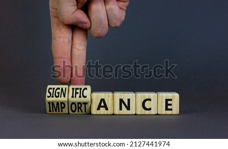 Significance and importance symbol. Businessman turns cubes changes the word importance to significance. Beautiful grey background, copy space. Business, significance and importance concept.