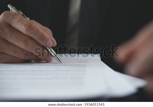 Signing contract, business agreement, deal\
concept. Businessman signing official contract, formal document,\
close up. front view. Man manager proofing terms and condition of\
business document