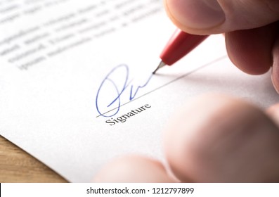 Signing contract, lease or settlement for acquisition, apartment lease, insurance, bank loan, mortgage or business buyout. Man writing name and autograph with pen. The signature is made up. Macro. - Shutterstock ID 1212797899