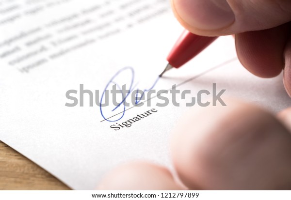 Signing contract, lease or settlement for\
acquisition, apartment lease, insurance, bank loan, mortgage or\
business buyout. Man writing name and autograph with pen. The\
signature is made up.\
Macro.