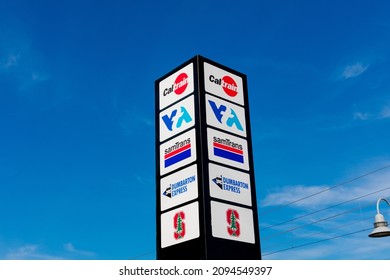 Signpost With Names Of Public Transportation Transit Services - SamTrans, Caltrain, VTA, Dumbarton Express, Marguerite Shuttle - Palo Alto, California, USA - 2021