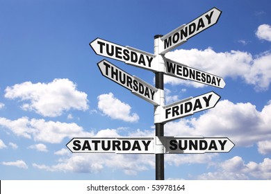 A signpost with the seven days of the week on the directional arrows, against a bright blue cloudy sky. Good image for a 24/7 related theme.