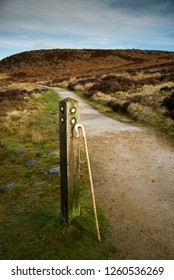 Signpost Showing Where The Footpaths Are. A Shepherds Crook Leans Against It, Burbage, Peak District, England, UK