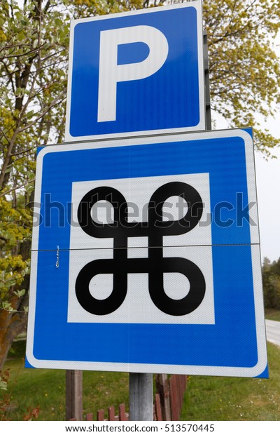 Signpost with Swedish road signs for car paring\
and national heritage.