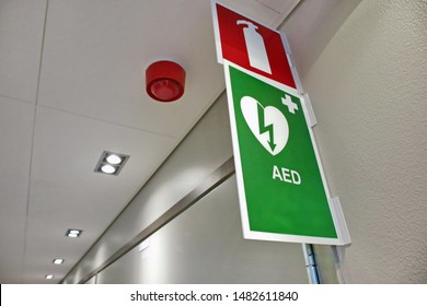 Signs Of AED Emergency Defibrillator And A Fire Extinguisher On The Wall In The Hospital Corridor