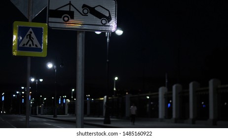 Signs Of Pedestrian Crossing And Tow Truck. Stock Footage. Road Signs On Pole On Background Of City At Night In Light Of Lanterns