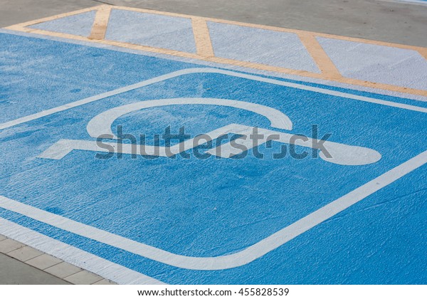 Signs for\
people with disabilities on the car\
park.