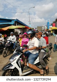 Sihanoukville, Cambodia. February 25, 2019: Lady Carrying A Child In Fashionable Pyjamas Busily Walking Outside The Street At Phsar Leu Market. 