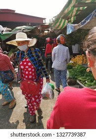 Sihanoukville, Cambodia. February 25, 2019: Lady Carrying A Child In Fashionable Pyjamas Busily Walking Outside The Street At Phsar Leu Market. 