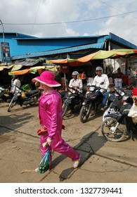 Sihanoukville, Cambodia. February 25, 2019: Lady Carrying A Child In Fashionable Pyjamas Busily Walking Outside The Street At Phsar Leu Market. 