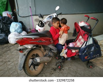 Sihanoukville, Cambodia. February 25,2019 : Big brother taking care of baby sister at motorcycle park while parent marketing at Phsar Leu market.