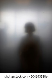 Sihouette of girl highly diffused by frosted glass