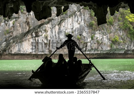 Sihouette of a rowing boat in the dark caves of Halong Bay, Vietnam.  Rowing boats take tourists to see the geology of the area up close. It is a world UNESCO Heritage Site.