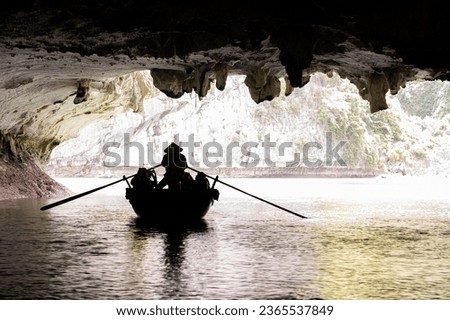 Sihouette of a rowing boat in the dark caves of Halong Bay, Vietnam.  Rowing boats take tourists to see the geology of the area up close. It is a world UNESCO Heritage Site.