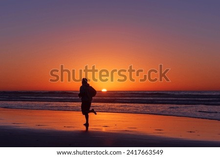 Sihouette of running man at Scripps Pier, La Jolla, California