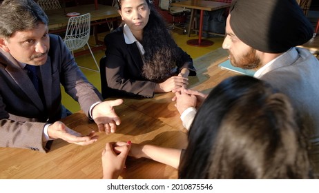 A Sikh Man Wearing The Black Turban With His Colleagues From India In The Workplace Having A Meeting