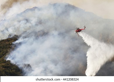 Sikorsky S-64 SkycraneType I Heavy Lift Helicopter, Drops Water On A Brush Fire.