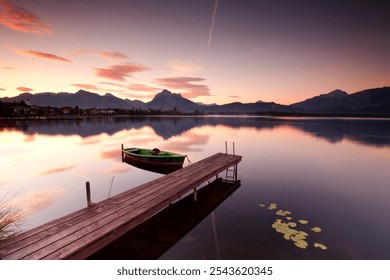 silence in the morning, calm mood on the wooden boardwalk with old fishing boat, tranquil mountain lake with sunrise light - Powered by Shutterstock