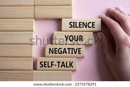 Silence your negative self-talk symbol. Concept words Silence your negative self-talk on wooden blocks. Doctor hand. Beautiful pink background. Psychology concept. Copy space.