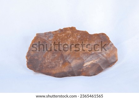 Silex fragment in pure form, raw material used for lithic industry at prehistoric times. Isolated over white fabric cloth