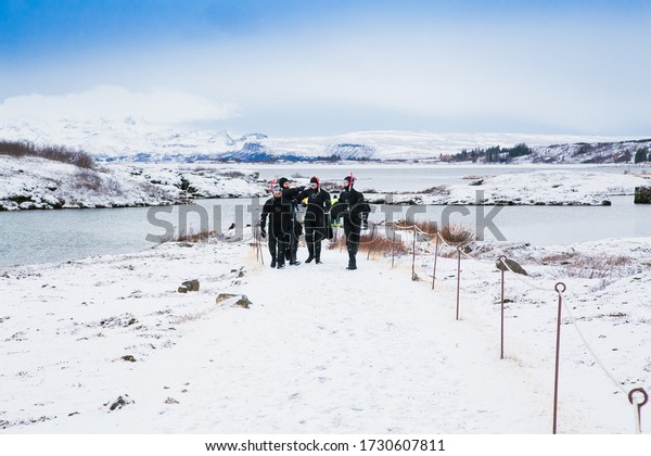 Silfra, Iceland-Feb 19, 2020: Scuba divers preparing\
entering in the water at Silfra rift, the place where Eurasian and\
the American tectonic plate are divided in Thingvellir National\
Park, Iceland. 