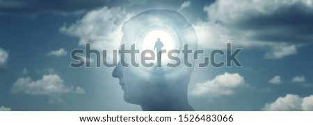 A silhouete of a man with rays of light emanating from the brain as a symbol of the power of thinking. Concept on the topic of psychiatry (bipolar disorder, schizophrenia), psychology, religion.