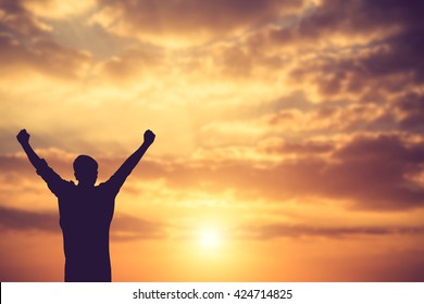 silhouette achievements successful arm up man is celebrating success with sunrise.Vintage color - Shutterstock ID 424714825