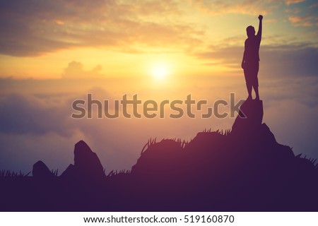 silhouette achievements successful arm up man is celebrating success with sunrise.Vintage color