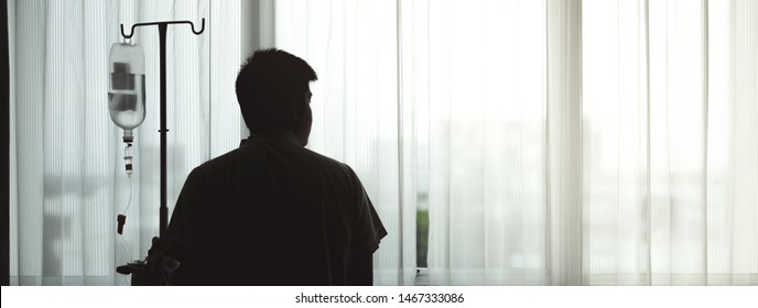 Silhouette Adult Patient Hold Infusion Hanger Pole Look Out To Hospital Window, Thinking About Medical Expenses And Health Care Insurance Alone, Financial And Wellness Problem Concept With Copy Space.