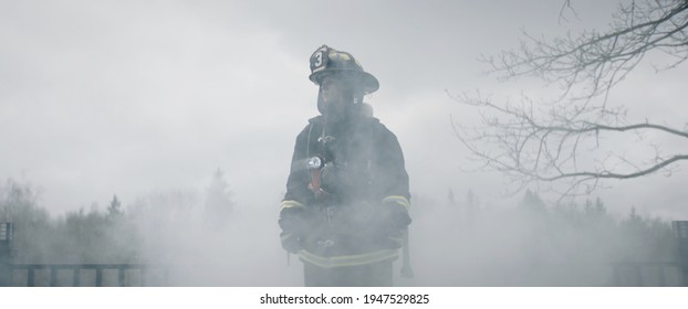 Silhouette of American female firefighter in traditional helmet and full gear standing in the smoke. Shot with 2x anamorphic lens - Powered by Shutterstock