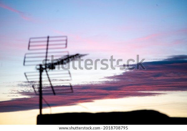 Silhouette of\
antennas on the roof during the\
sunset