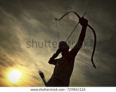the silhouette of an archer with twilight background