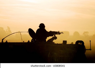 Silhouette Of An Army Soldier On Army Tank At Sunset. Concept Photo Of War ,military, Army, Armed Forces, Incursion,conflict ,firearm ,battle, Attack. 
