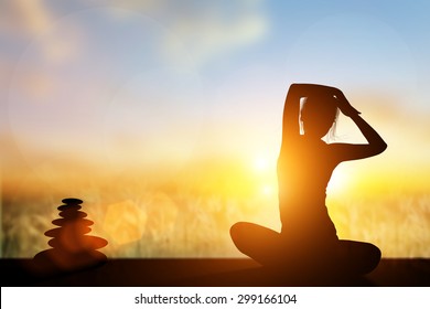 Silhouette Asia Woman Yoga On The Beach At Sunset.