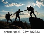 Silhouette of Asian Male and female hikers climbing up mountain cliff and one of them giving helping hand with friend at sunset, People helping, Asia couple hiking help each other concept.