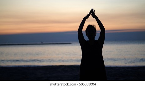 silhouette Asian senior woman doing yoga at morning beach  - Powered by Shutterstock