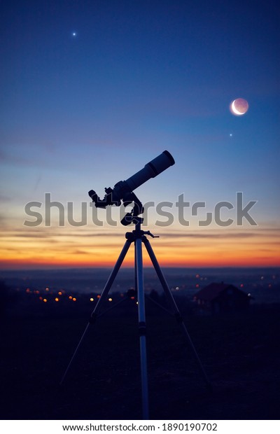 Silhouette of\
a astronomy telescope with twilight\
sky.