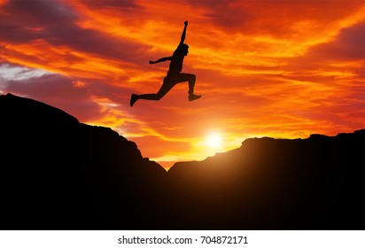 Silhouette of athlete, jumping over rocks in mountain area against sunset. Training running and jumping in difficult conditions in a beautiful nature with cloudy sky
